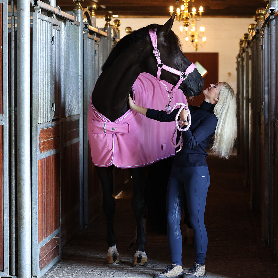 Fleecedækken i den flotte farve Begonia Pink vist forfra i stalden vist med matchende grime og træktov