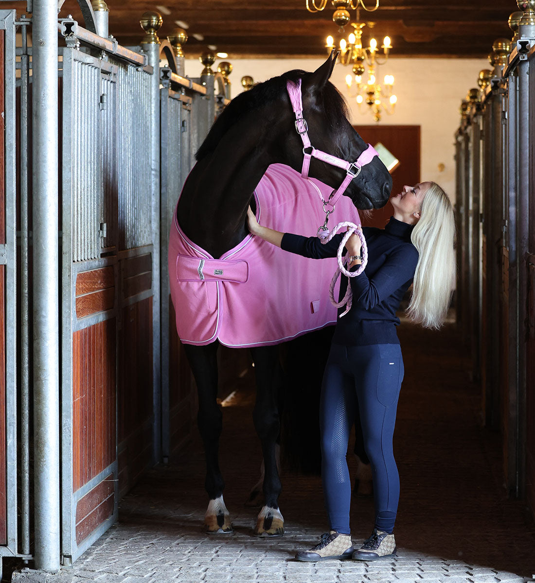 Fleecedækken i den flotte farve Begonia Pink vist forfra i stalden vist med matchende grime og træktov