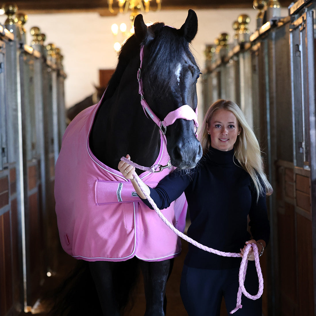 Fleecedækken i den flotte farve Begonia Pink vist forfra i stalden vist med matchende grime og træktov
